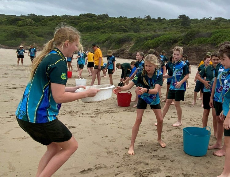 Student sitting and reflecting as they finish thier nature journal using water colours